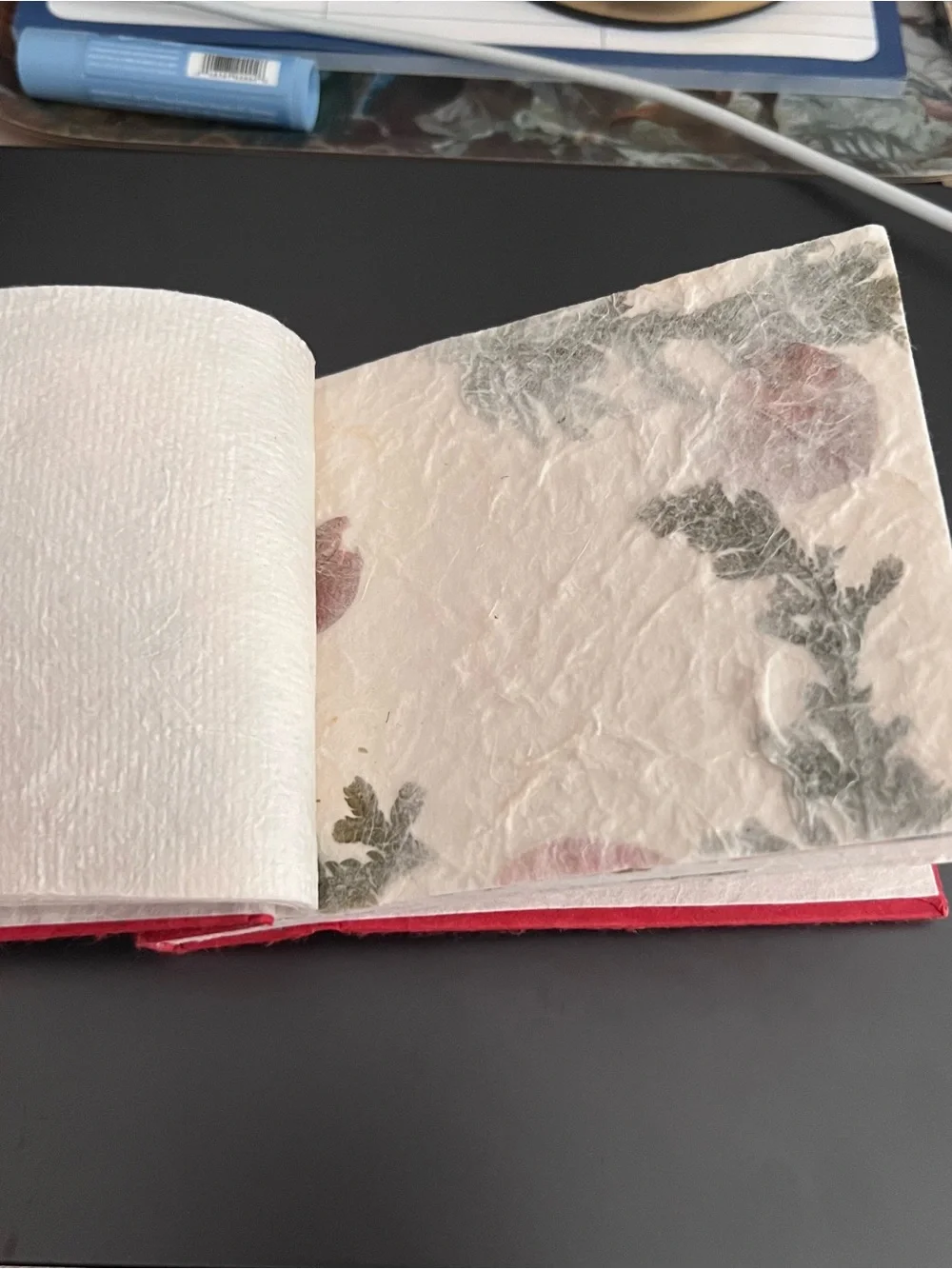 Red handmade notebook with gold Buddha face graphic and 'LAOS' text